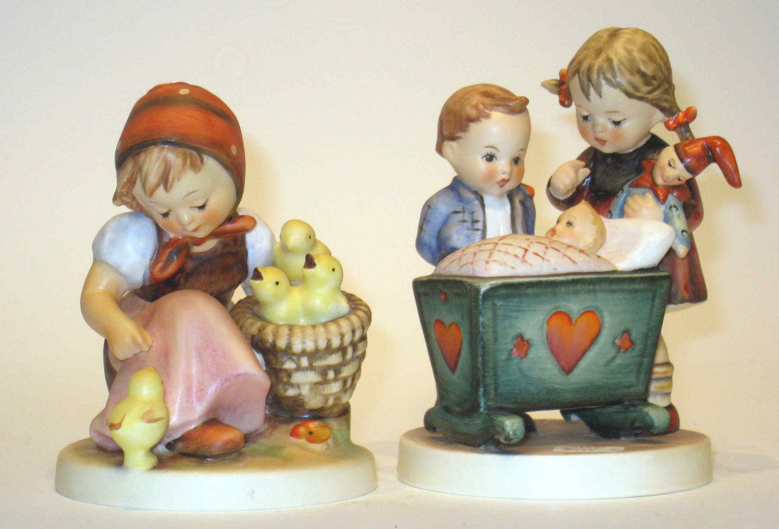 Two Hummels: One with a boy and girl aside the baby crib " Blessed Event" and the other the girl feeds chicks, each about 5 1/4".