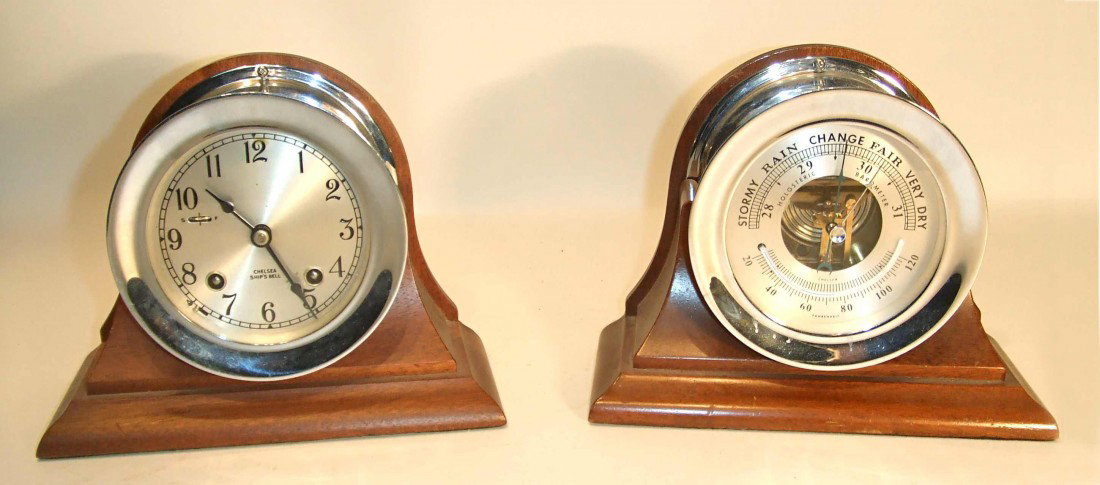A Chelsea Weather/Clock Set: A chrome plated weather and clock stand, with each items displayed on a separate wood molded base. The clock having the ships bells with the usual aneroid barometer and thermometer. Each item is 6" X 