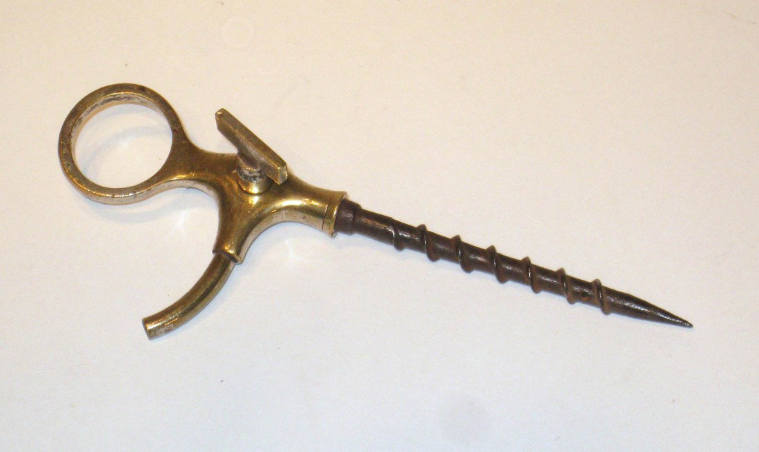 Unusual Corkscrew: A brass and steel corkscrew whose steel screw shaft has a hole reaching into the brass top. When the screw is sent down into the unopened bottle and the bottle turned upside down, the stop cock will d