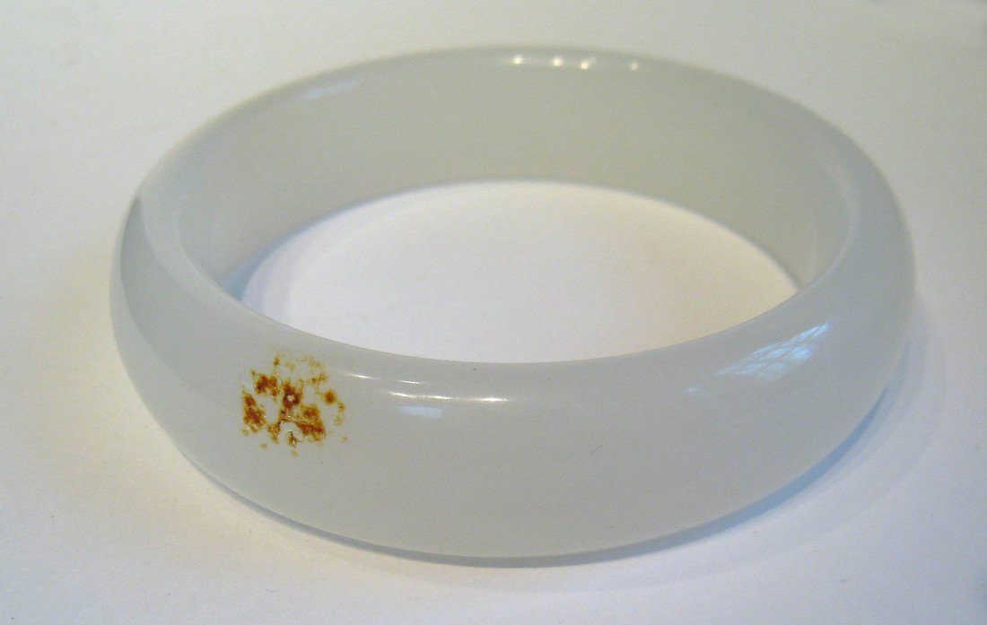 White hardstone bangle: A well made white bangle with an outside diameter of 3 1/4" and inside diameter of 2 1/2". NOTE THIS WAS PREVIOUSLY DESCRIBED AS "JADE", AND ALTHOUGH STILL UNTESTED, WE NOW DOUBT THE MATERIAL ENOUGH T