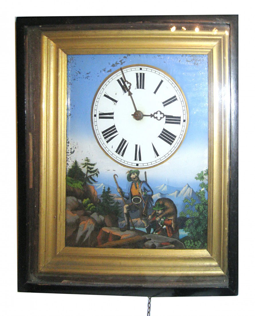 Picture Frame Wall Clock: A weight driven wall clock of the 19th century featuring a reverse painted and polychrome scene of the black forest. Complete with weights and pendulum.