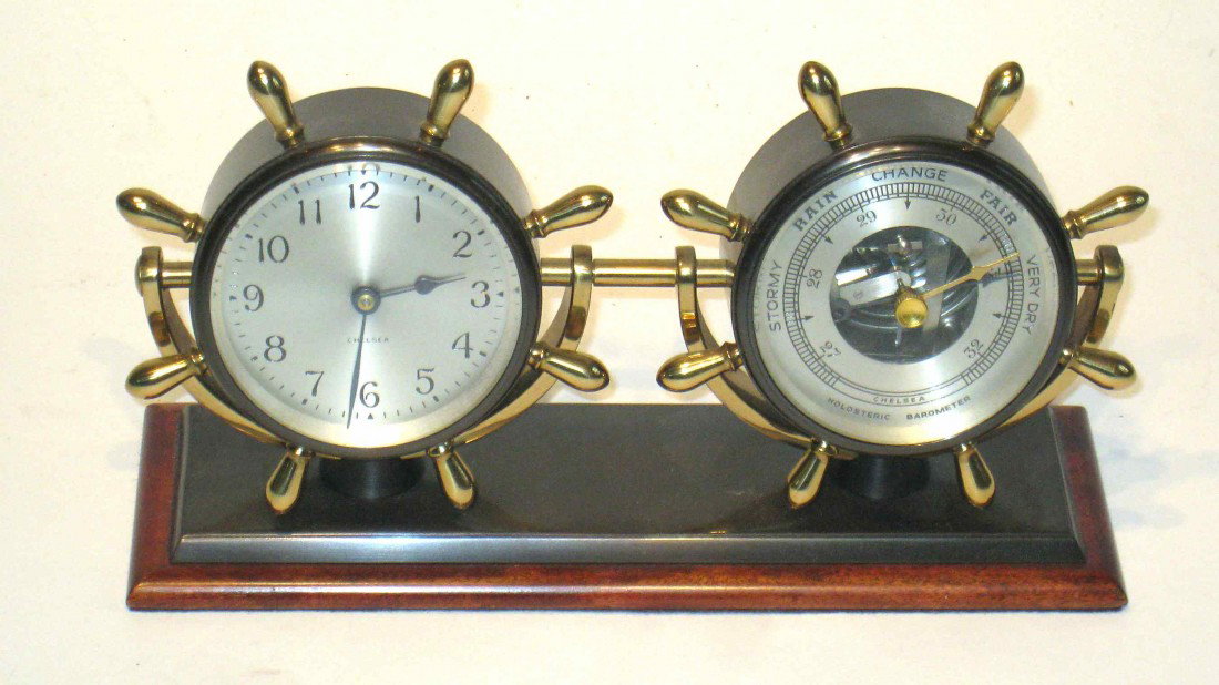 Chelsea Desk Set "Corvette": A Chelsea timepiece and barometer mounted onto a wood and bronzed brass base, 9" long, 3" deep. Polished brass spokes. 9" X 3"