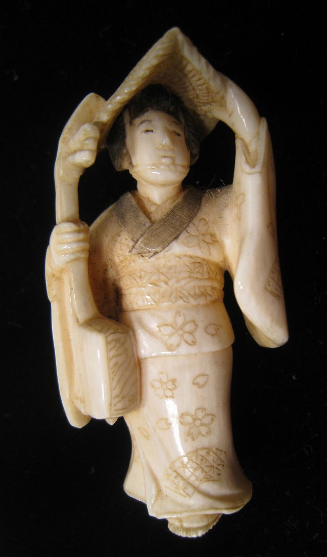 Japanese Netsuke: A carved ivory Netsuke of a Japanese woman with a large hat. Shipping: We are able to pack and ship this item to an address in the United States for $15.00 via USPS Priority Mail. Tracking information