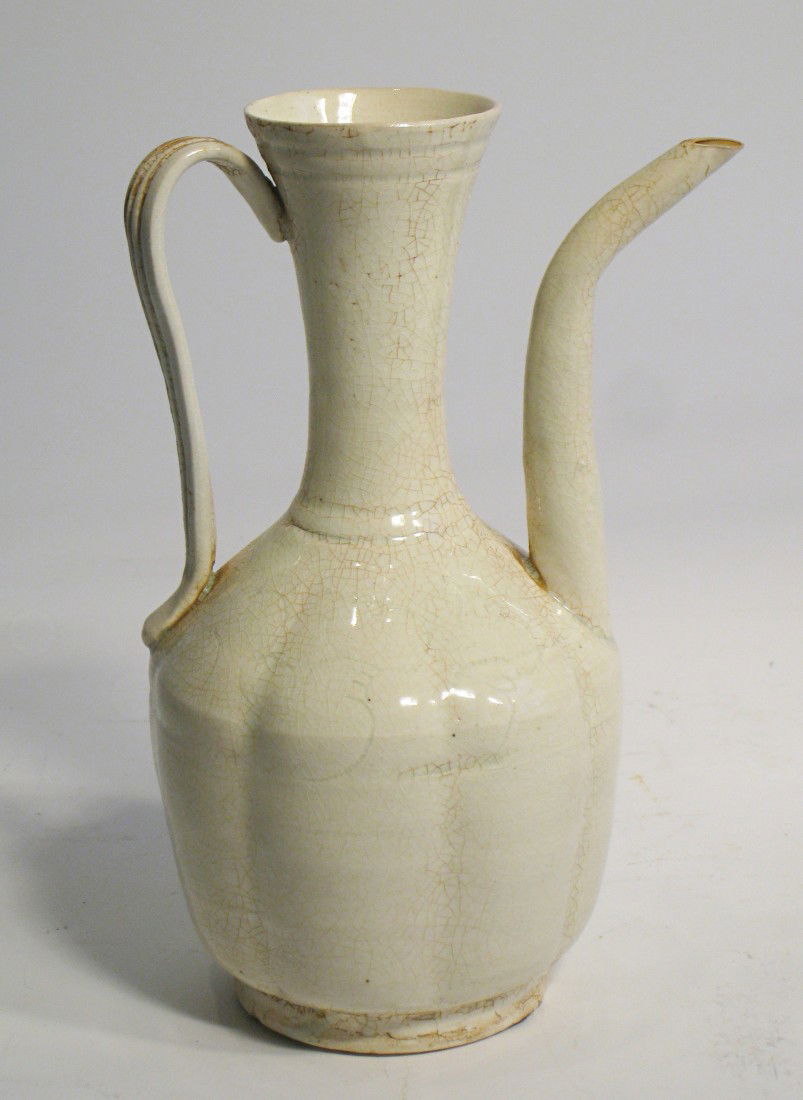 Song Dynasty Wine Pitcher Or Ewer: A Chinese white celadon glazed wine pitcher or ewer in a delicate white glaze with crackleature. 7" tall. Shipping: We are able to pack and ship this item to an address in the United States for $30.00