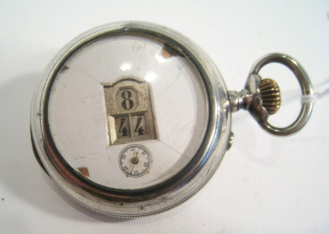 A Collectable Digital Display Watch: A late 19th C. .800 silver cased watch with a white porcelain dial with apertures for the hours and minutes, with a seconds hand. The dial is damaged with losses at about the 10:00 position and other 