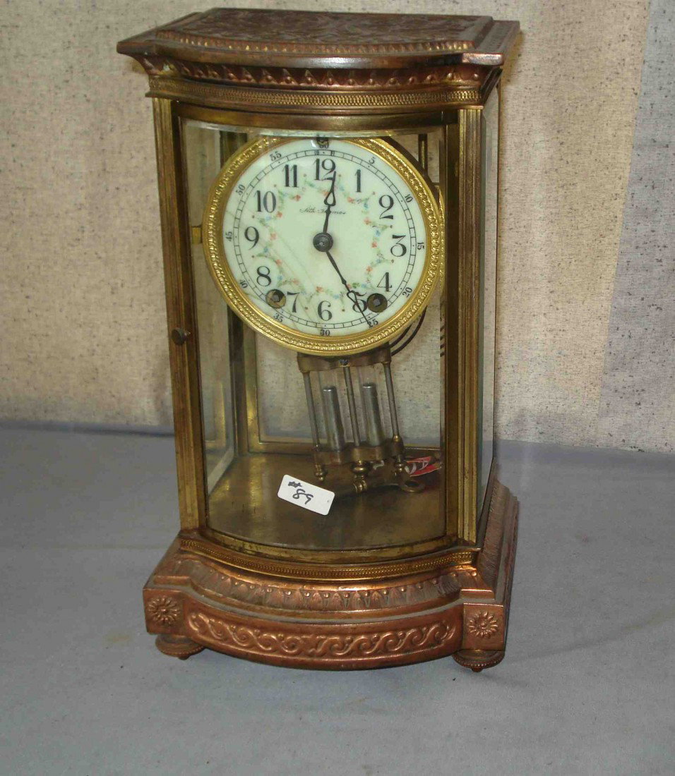 Bevel Glass Crystal Regulator By Seth Thomas: 12 1/2" tall, with a faux Mercury pendulum, featuring a bowed front glass. The gold plated metal casement shows wear from the gold finish. Shipping: We are unable to ship this item. Please contact our