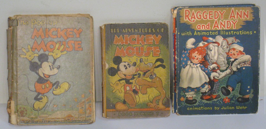Three Childrens Books, Mickey Mouse Pop Up: 2 Mickey Mouse books and 1 Raggedy Ann & Andy book. One Mickey Mouse is a Pop Up book. In poor condition. Shipping: We are able to pack and ship this item to an address in the United States for $25.00