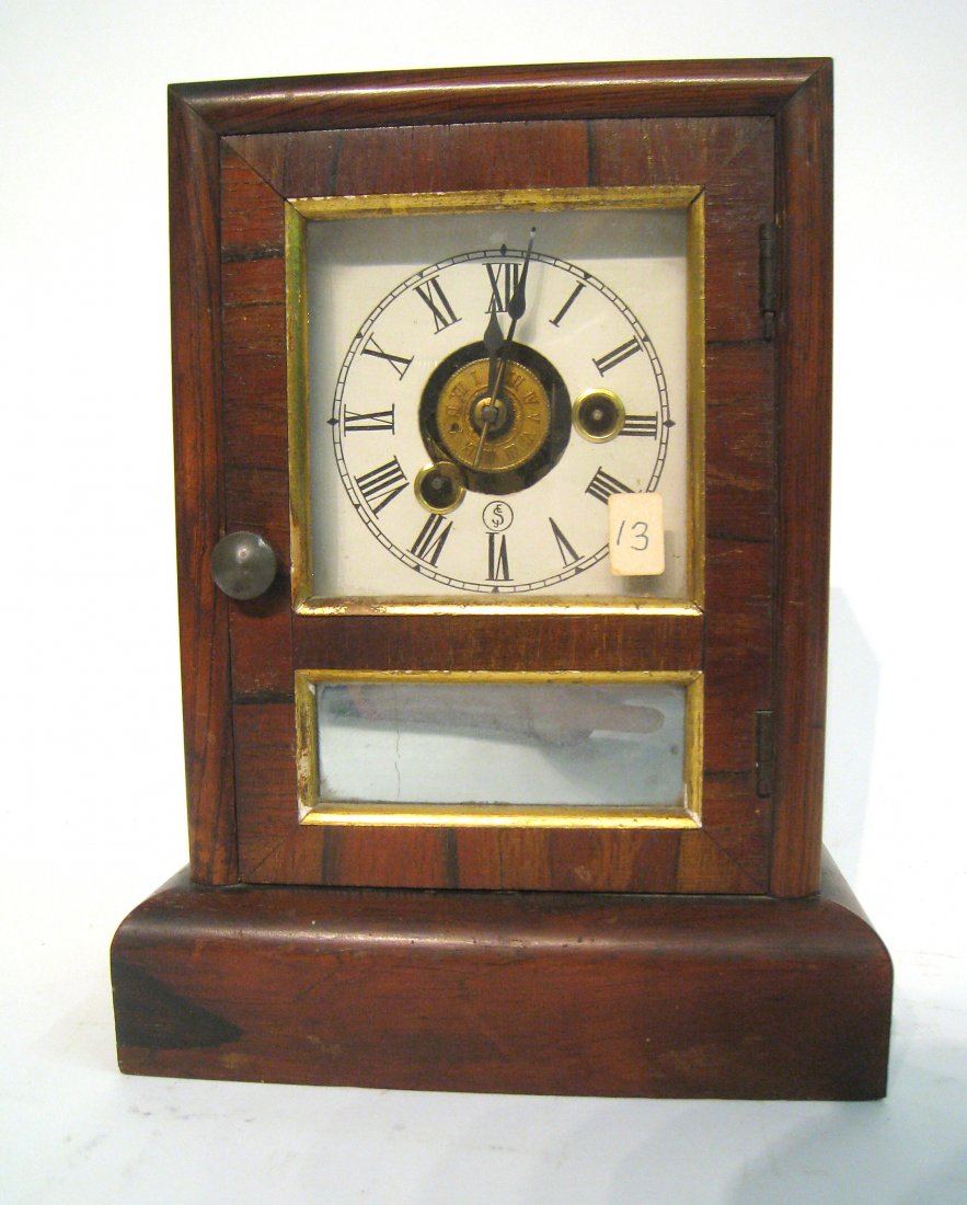 Cottage Clock: By Seth Thomas, a late 19th century 9 1/2" veneer cased clock fit with alarm. Shipping: We are able to pack and ship this item to an address in the United States for $40.00 via USPS Priority Mail or v