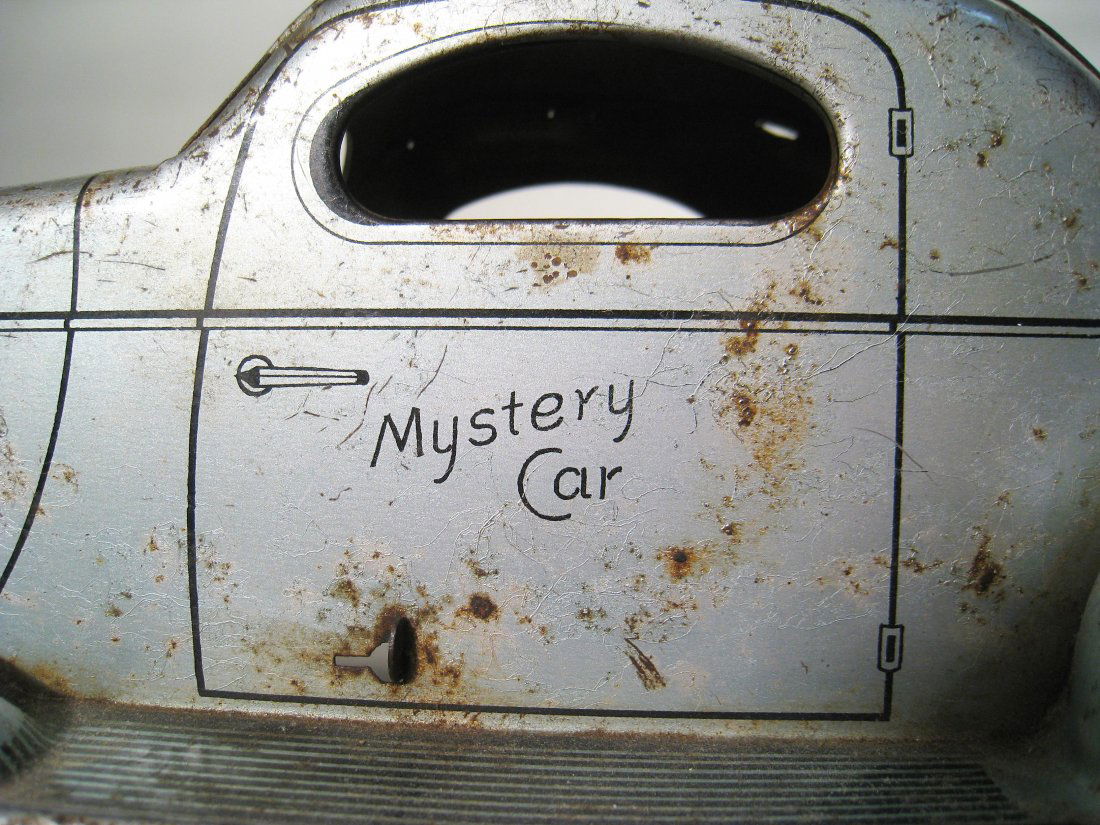 Mystery Car: A silver painted metal 13" toy "Mystery Car" with defective friction drive. Shipping: We are able to pack and ship this item to an address in the United States for $50.00 via USPS Priority Mail or via