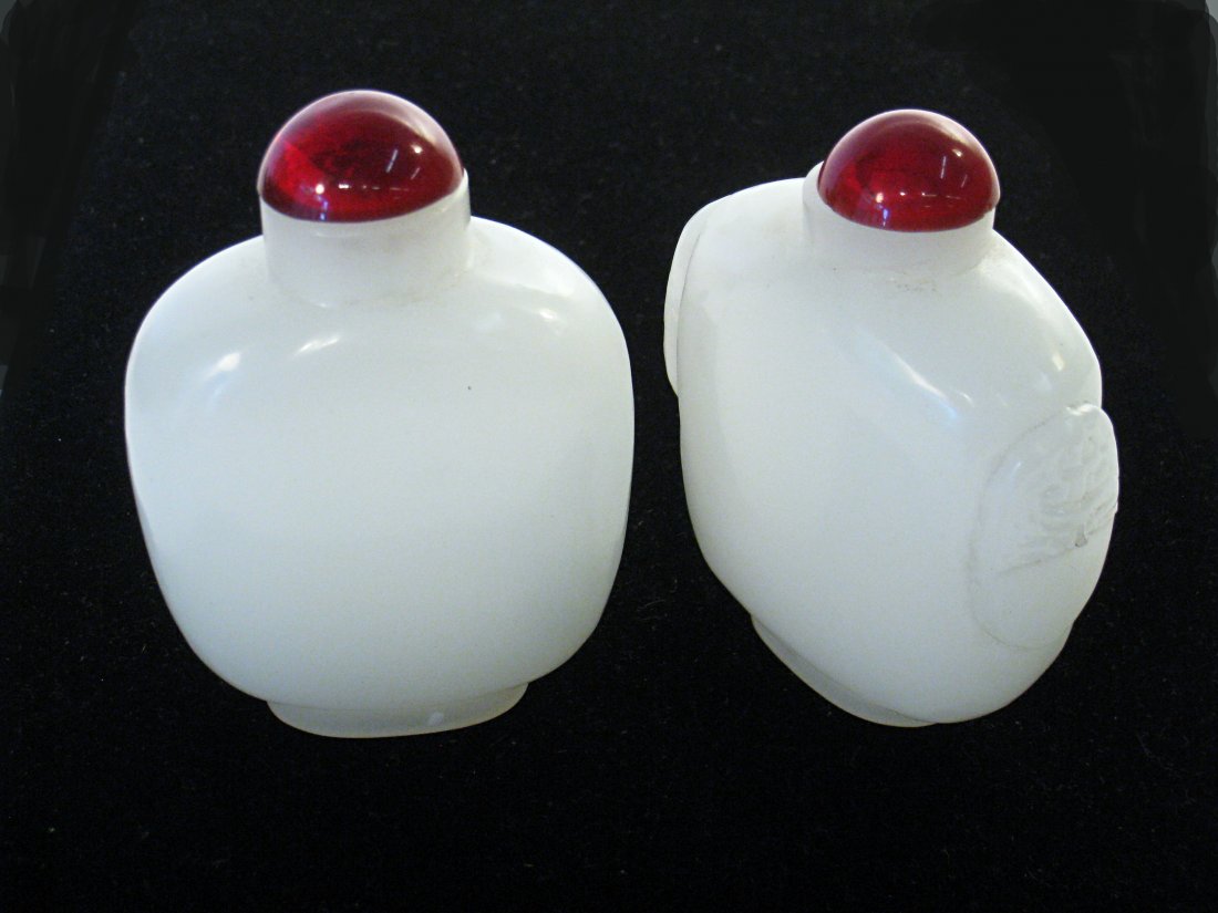 Pair Of White Chinese Snuff Bottles: Two 3 3/4" snuff bottles both in white hard stone. One with carved decoration on the side, one without. Shipping: We are able to pack and ship this item to an address in the United States for $25.00 v