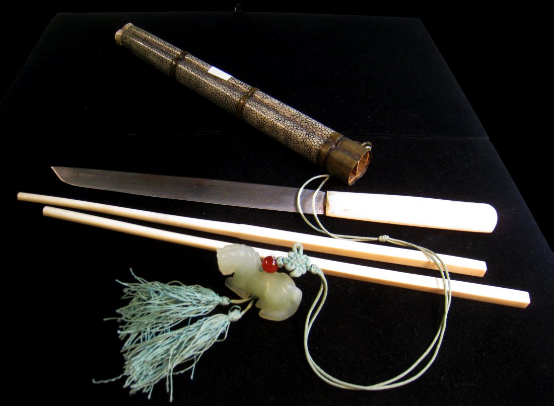 Shagren And Brass Bound Dining Set: A dining set consisting of two carved bone chop sticks and a bone handled knife with a high quality carved jade horse. The casement, designed for carrying on the belt, is green dyed shagreen. Shipping