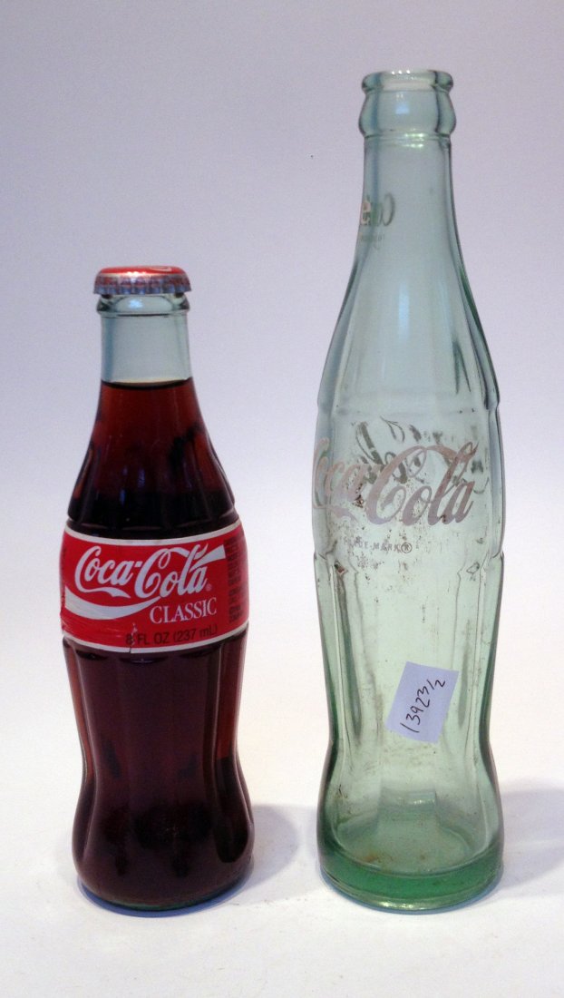 Two Classic Coca-Cola Bottles: One is unopened. Tallest is about 9 3/4". Shipping: We are able to pack and ship this item to an address in the United States for $25.00 via USPS Priority Mail. Tracking information will be sent to yo