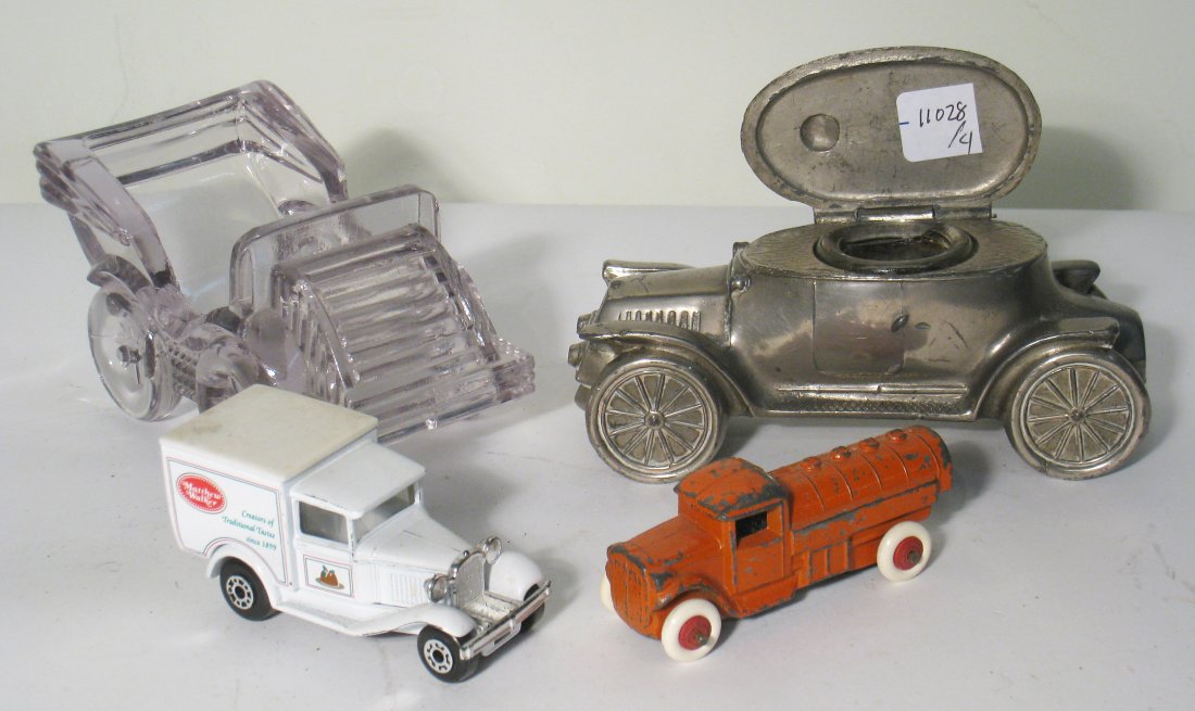 Four Automobile Related Collectables.: A white delivery truck, a red cast metal truck, a die cast vehicle and a glass car. Shipping: We are able to pack and ship this item to an address in the United States for $25.00 via USPS Priority Mai