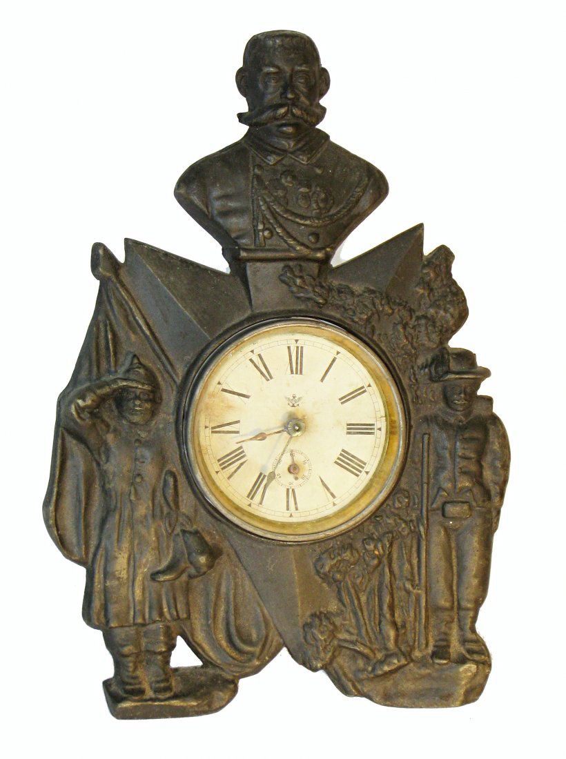 Cast Iron Commemorative Clock: A cast iron cased clock showing what appears to be the Kaiser (WW I?) with a balance wheel movement. The clock not running. About 12" tall. Shipping: We are able to pack and ship this item to an addre