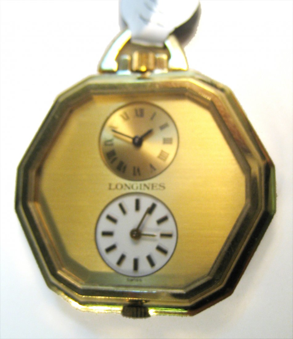 Longines Unusual Dual Time Zone Watch: A 20th century gold twelve sides gold cased watch with two dials (each separately powered with independent stem settings and windings) against a gold mask . Shipping: We are able to pack and ship this