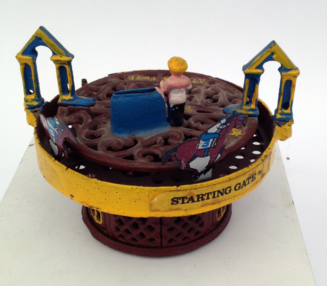 Savings Bank In The Form Of A Horse Race: A painted circular race track is the frame for this mechanical bank. Shipping: We are able to pack and ship this item to an address in the United States for $40.00 via USPS Priority Mail or via FedEx