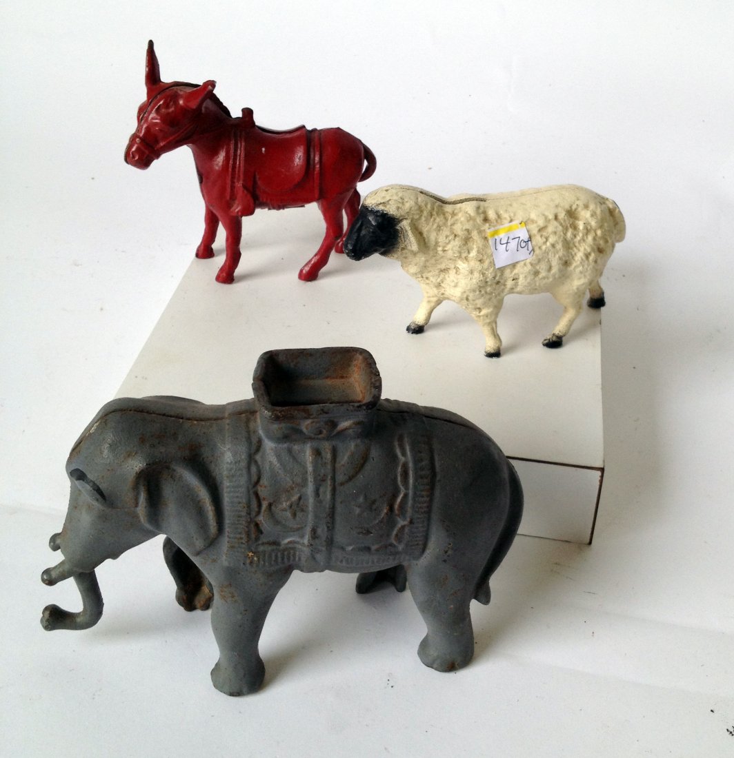 Three Animal Toy Savings Banks: With a cast iron sheep, elephant, and red painted donkey. Shipping: We are able to pack and ship this item to an address in the United States for $40.00 via USPS Priority Mail or via FedEx Ground/Home