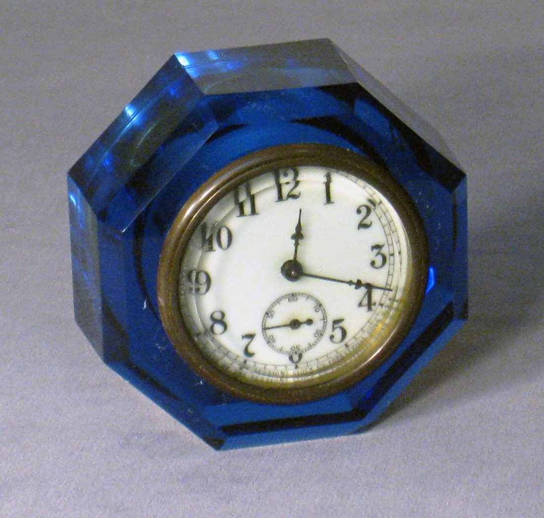 Dark Blue Glass Cased Desk Clock: By the Sessions clock company, being 4" X 1 3/4" and with a dark blue solid glass case. Shipping: We are able to pack and ship this item to an address in the United States for $25.00 via USPS Priority
