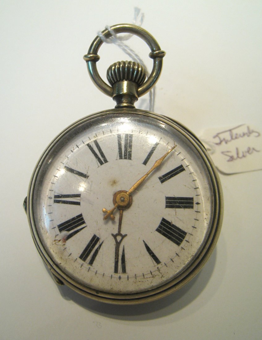 Exhibition Cased Watch: A nickel or silvered cased watch with an exhibition back showing the partially skeletonized movement. The Watch may be European in origin with a cylinder movement (running) and white porcelain dial wi