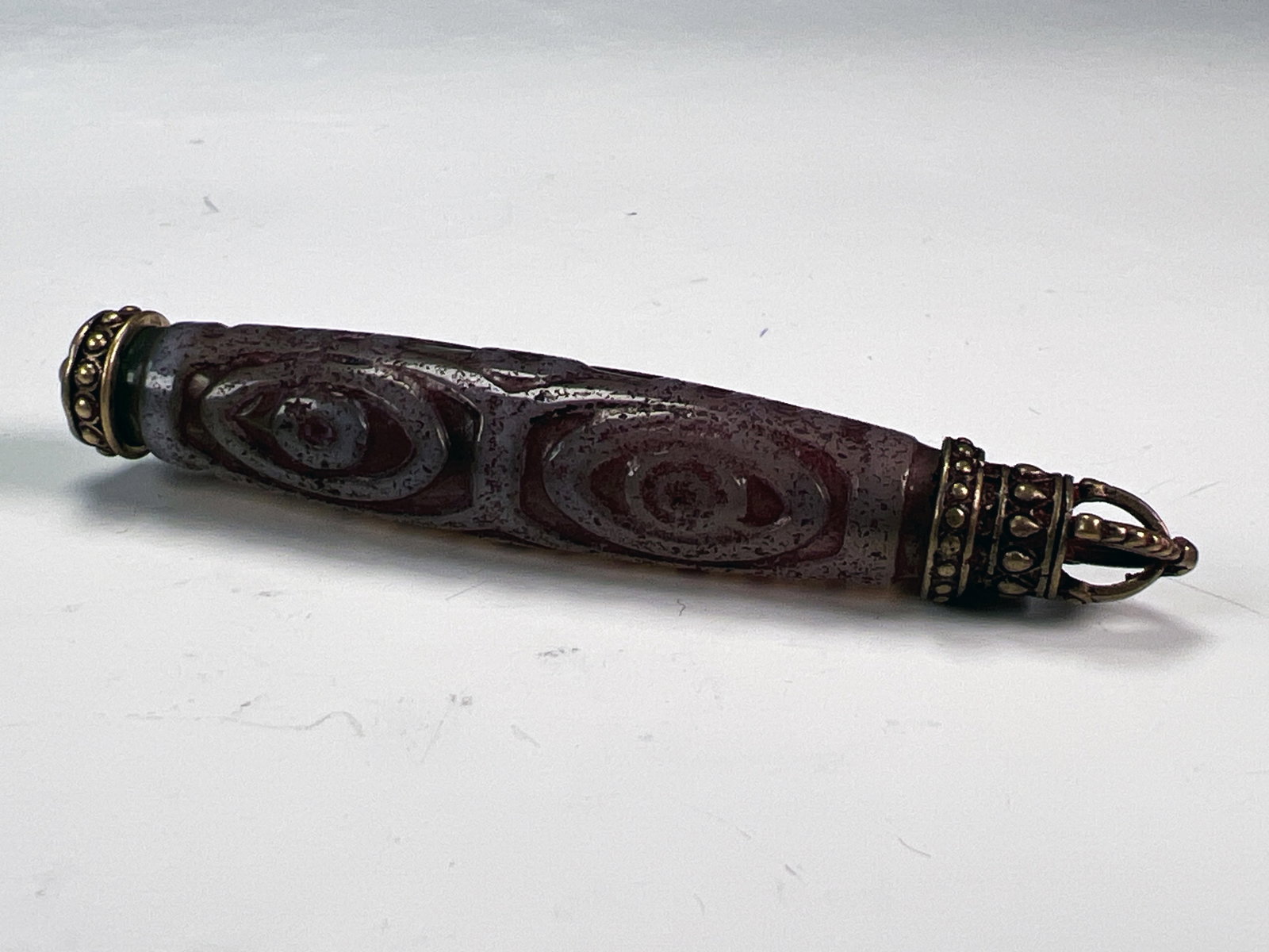 ETCHED DZI BEAD WITH ORNATE BRONZE VAJRA CAPS