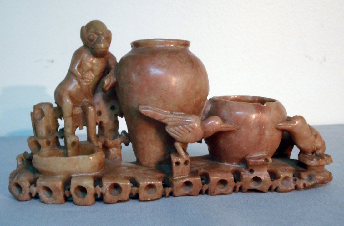 Chinese Soapstone Carving: An 8" soapstone desk accouterment carving, with modeled vessels for spring flowers surrounded by a monkey and ravens. Shipping: We are able to pack and ship this item to an address in the United State