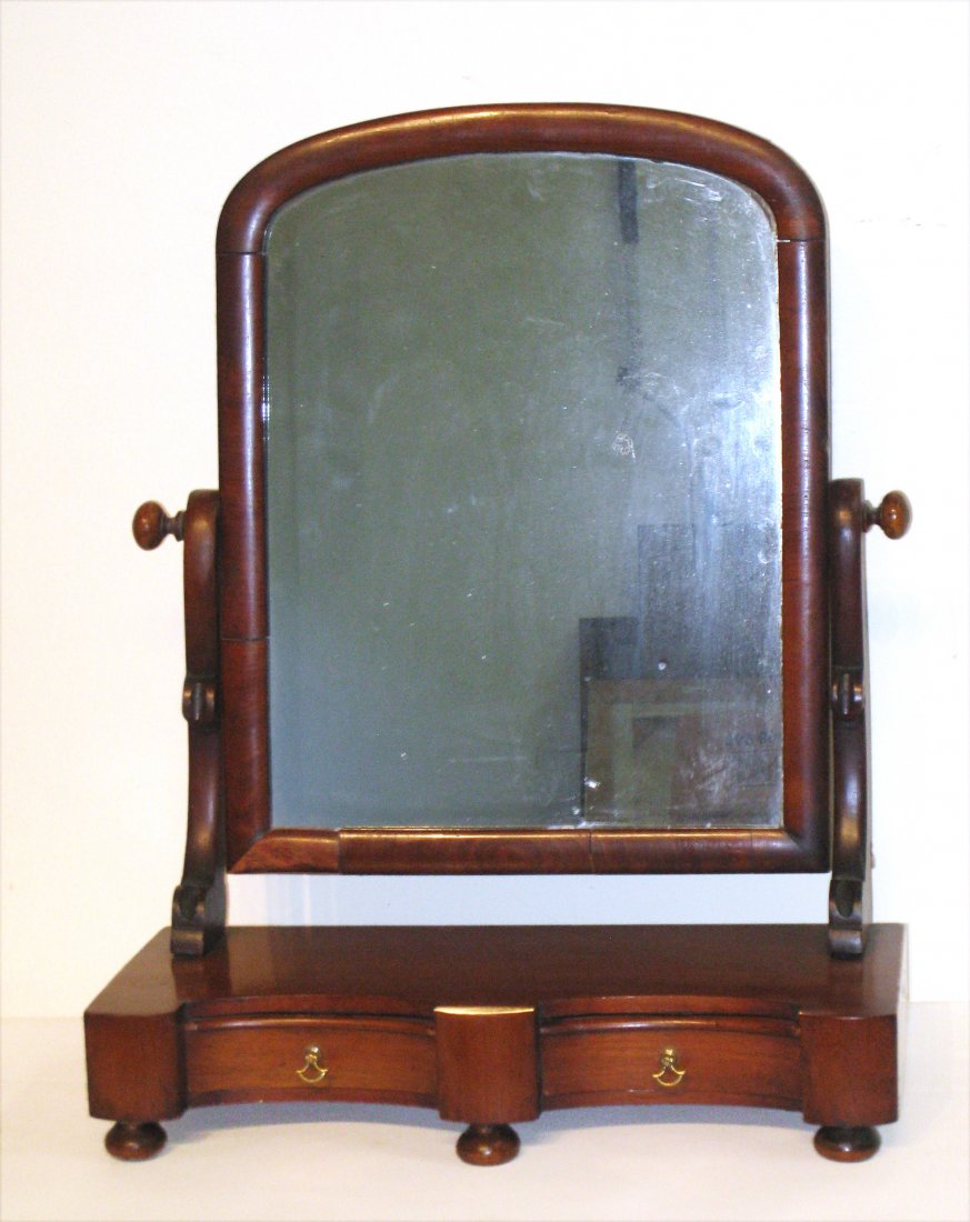 19th Century Shaving Mirror: A 19th C. mahogany shaving mirror mounted cheval style onto a small two drawer cabinet. Shipping: We are unable to ship this item. Please contact our local UPS Store, store1152@theupsstore.com, or the