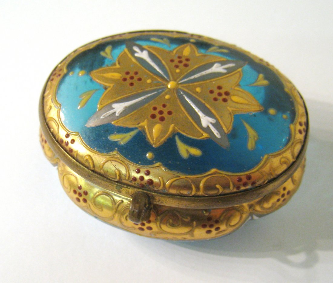 Glass Pill Box: An oval shaped 2 3/4" pill box of colored glass with gold and silver luster glazes. Shipping: We are able to pack and ship this item to an address in the United States for $25.00 via USPS Priority Mai