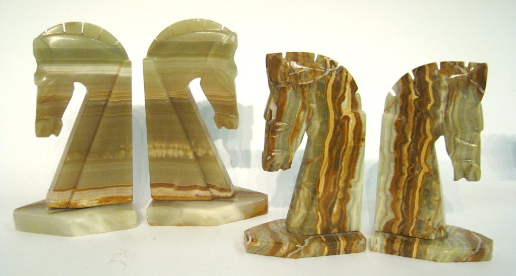 Five Bookends: Two sets of carved onyx horse head book ends, one with slight damage to the base. Tallest about 9". One not pictured. Shipping: We are able to pack and ship this item to an address in the United State