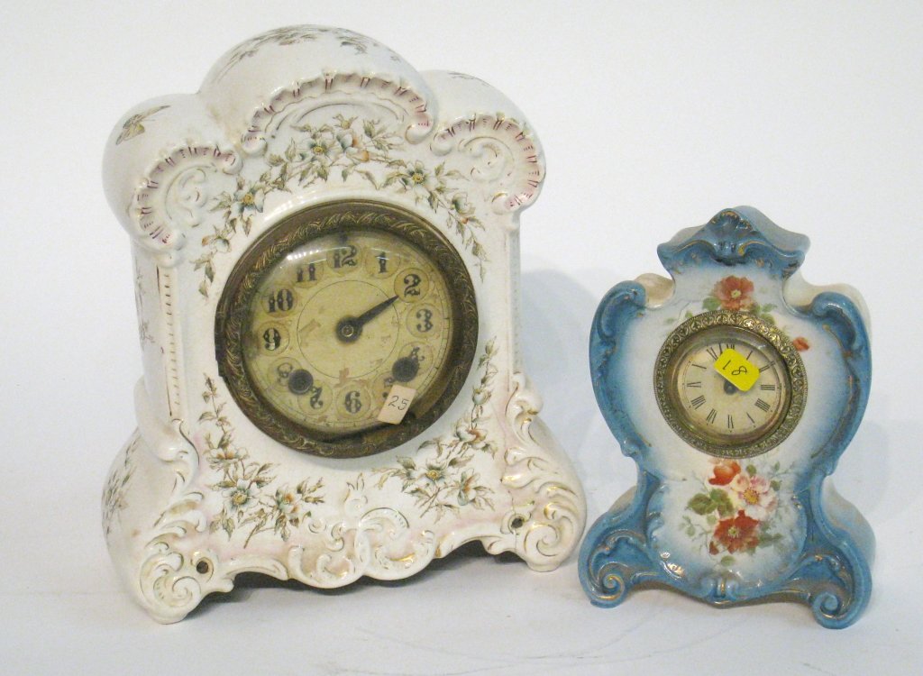 Two Porcelain Cased Clocks: An American China cased clock lacking hands and a smaller desk size example. Shipping: We are able to pack and ship this item to an address in the United States for $50.00 via USPS Priority Mail or vi