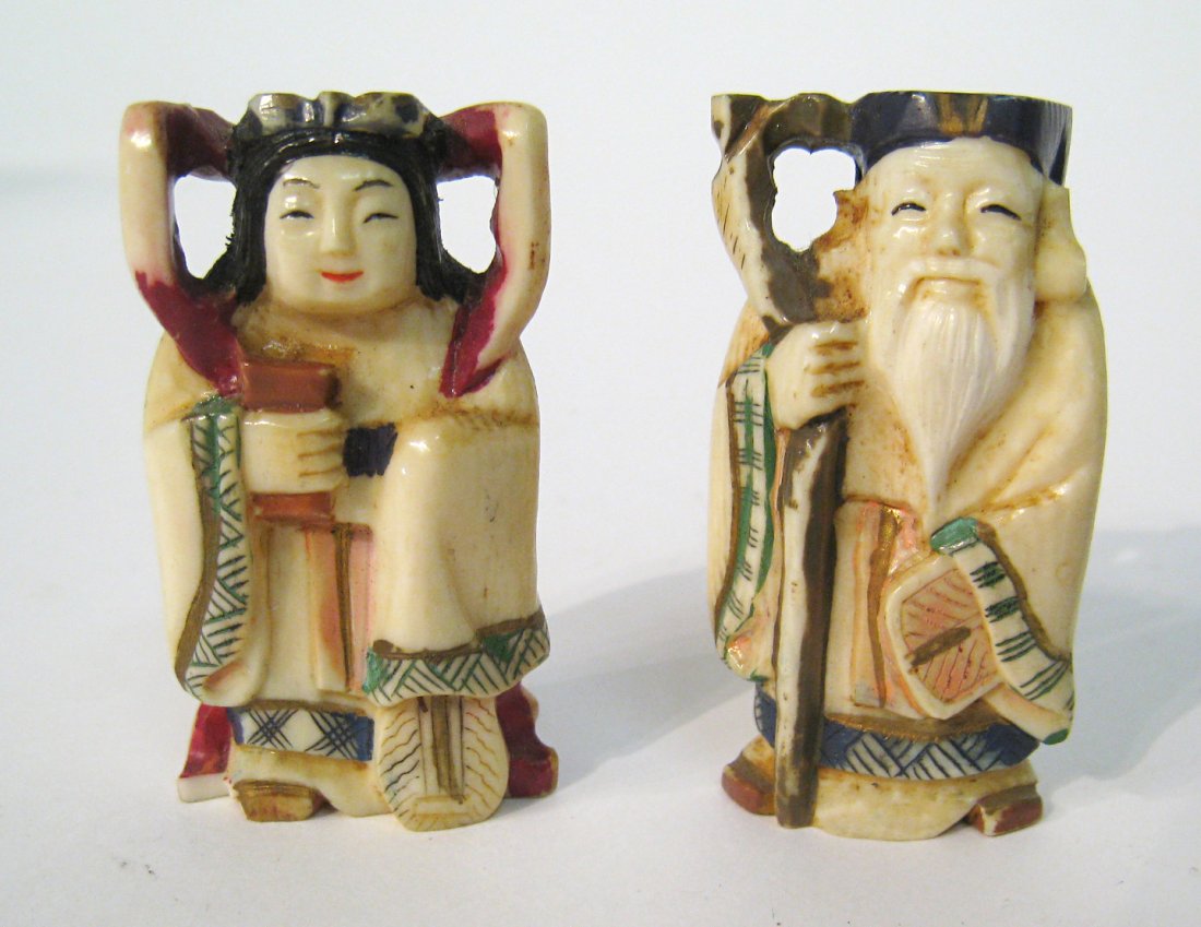 Chinese Or Japanese Carved Netsuke: A pair of ivory carvings, Netsuke,of a man an woman with each about 2" in height. Hand decorated and engraved ivory carvings. Shipping: We are able to pack and ship this item to an address in the Unit