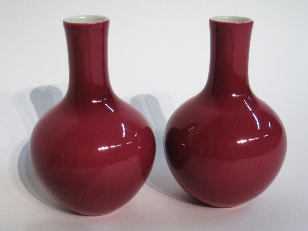 Pair Of Celadon Vases: 5" tall and in the bottle top form, with a bulbous base. In red oxblood celadon glaze and within a custom presentation box. . Shipping: We are able to pack and ship this item to an address in the Unit