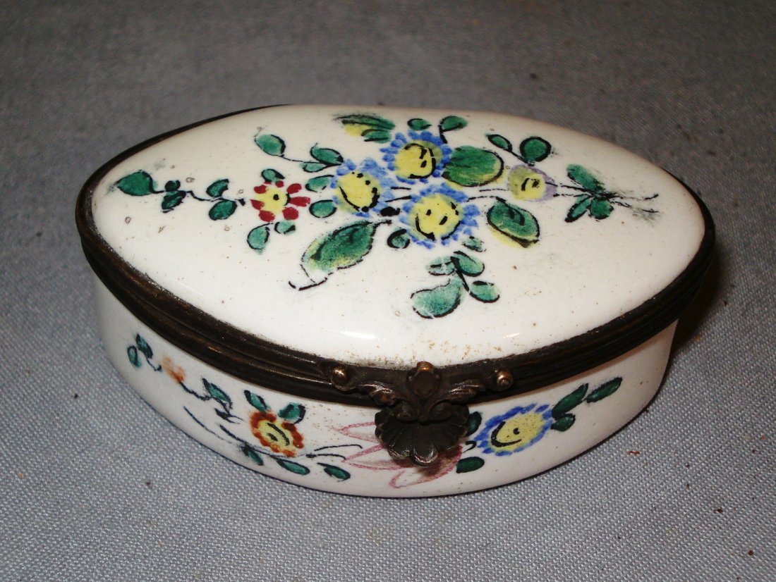 Porcelain Pill Box: A late 18th century or 19th century pill or patch box with a almost oval shaped and having a hinged lid opening to a plain interior. Decorated with flowers spray. 2"-3" Shipping: We are able to pack a