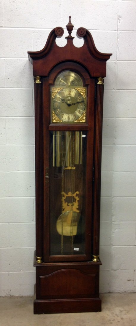 Chime Hall Clock by Howard Miller: A 20th century weight driven standing hall clock by Howard Miller in a mahogany case. The three weight clock chimes (with multiple selections) the quarter hours and strike the hours.The clock has been