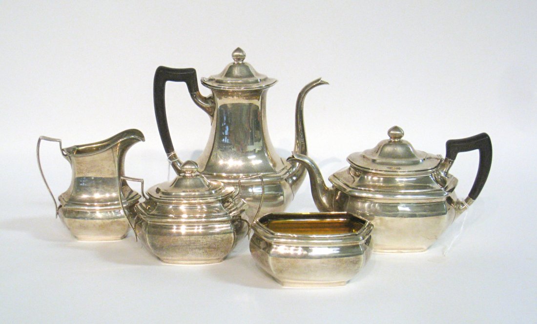 A Sterling Tea Set In Five Pieces:: Consisting of a tea and coffee pot (with ebony handles) , a sugar and a lidded creamer and waste. Weighing, including handles, about 60 OzT. Shipping: We are able to pack and ship this item to an addr