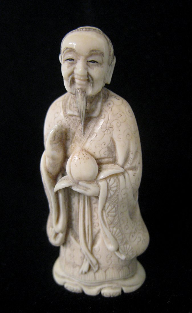 Ivory Netsuke Wise Man: Standing and holding forth a ripened fruit and signed on the back. About 2". Shipping: We are able to pack and ship this item to an address in the United States for $25.00 via USPS Priority Mail. Trac