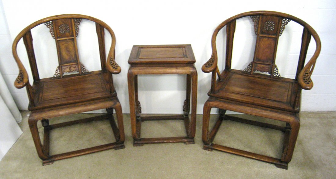 Chinese Huanghuali Chairs And Table: A pair of wrap around arm rest with carved and pierced back splat, 40 in height, and with a 29" matching end table. 19th century. A three piece lot, as shown. Shipping: We are unable to ship this item