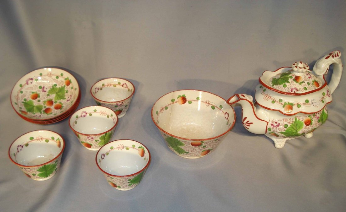 Early 19th Century Pearlware Tea Set: A pearl ware tea set in the strawberry pattern, including a 7" teapot, 5" waste bowl, and four tea cups with three 6" saucers. Waste bowl has been repaired. Otherwise there are minor chips and wear co