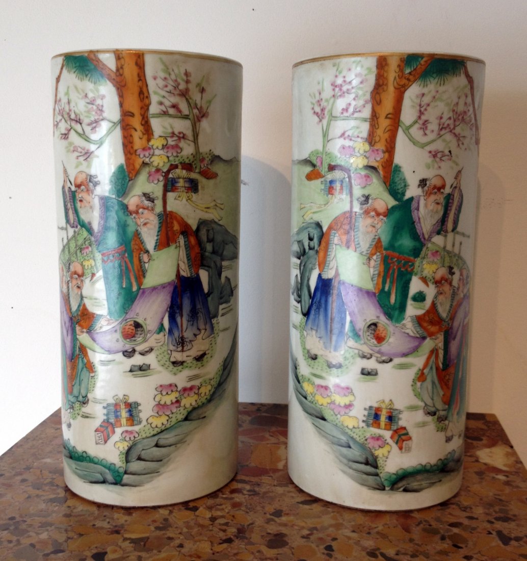 Pair Of Chinese Qing Garniture Vases: A Qing era pair of cylindrical vases. The polyglaze in a "Famille Rose" style shows wise men debating the "Ying and Yang". Each hand glazed with similar patterns that includes calligraphy on the side.