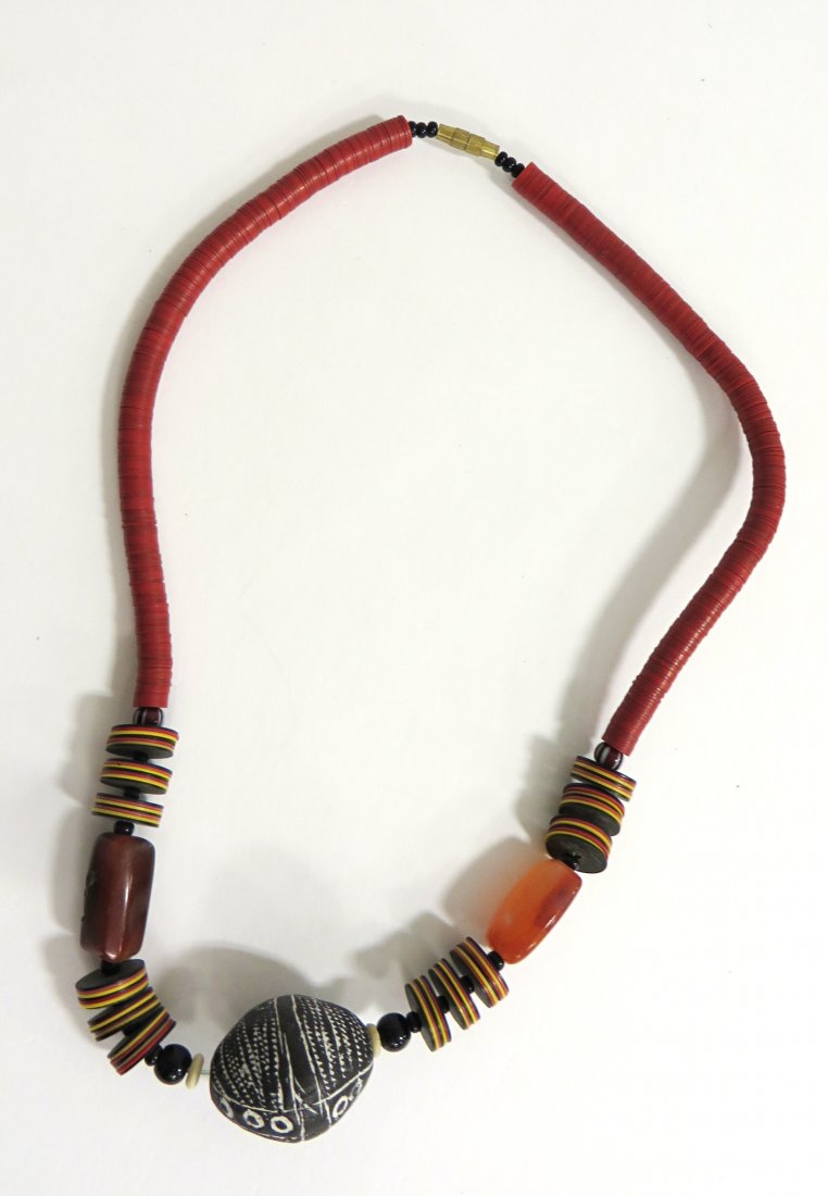 Jewelry By June Ruddell: A choker of resin or plastic disks with a central Mala bead, all in the African style. Shipping: We are able to pack and ship this item to an address in the United States for $15.00 via USPS Priority 