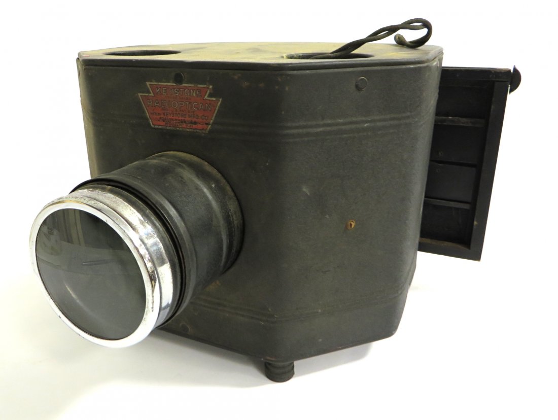 "Keystone Radioptican" Vintage Projector: A projector machine described as a "Keystone Radioptican", 9" X 15" X 13". Shipping: We are able to pack and ship this item to an address in the United States for $50.00 via USPS Priority Mail or via
