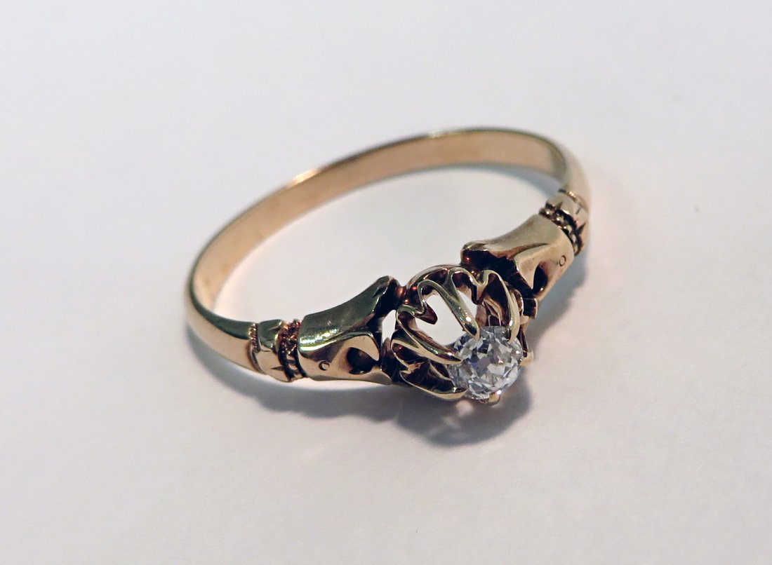 Diamond Ring: A gold ring with indistinct hallmark and a solitaire small diamond. We are not gemlogists. Our representations and opinions of these jewelry items are not guaranteed. The metals have not been tested a