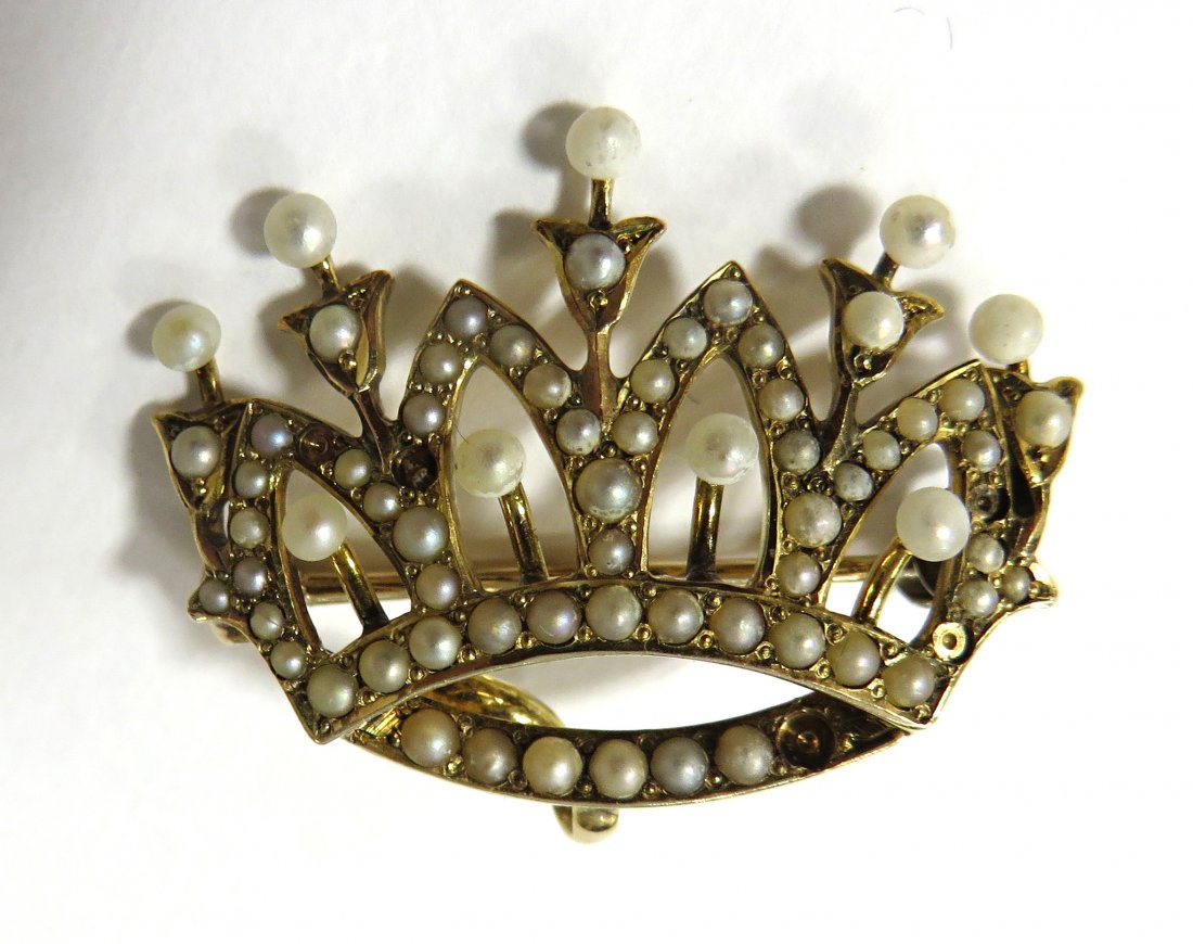 Crown Form Watch Pin: A gold pearl mounted watch pin set with seed pearls with a reverse mounted hook for displaying a small ladies watch. Stamped 14K. Few missing seed pearls. We are not gemlogists. Our representations an