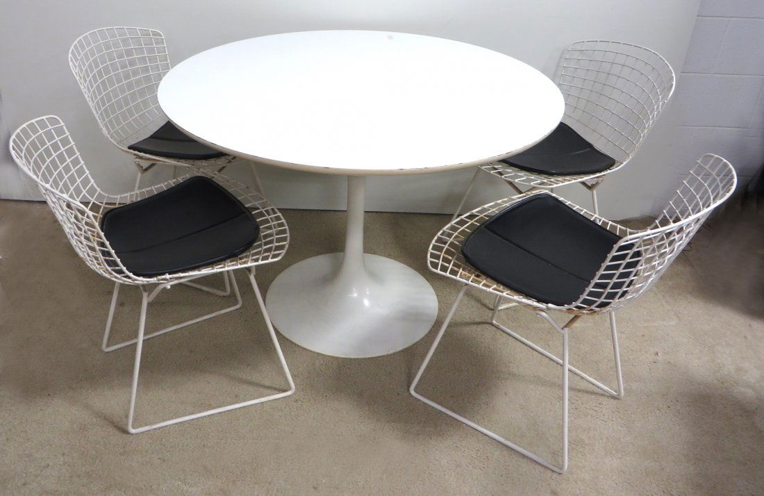 Table & Chairs In The Manner Of Eero Saarinen: A moderne style shaped 42" round top table and wire constructed chairs. Shipping: We are unable to ship this item. Please contact our local UPS Store, store1152@theupsstore.com, or the Packaging Store
