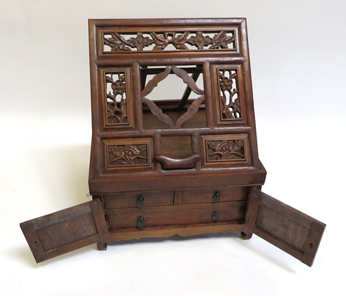 Huanghuali Book Stand: A carved cabinet fit on top with an adjustable easel form book stand above a hinged cabinet with drawers. Possibly mahogany. 7" X 13" square. Note damage to cupboard door hinge on left. Shipping: We a