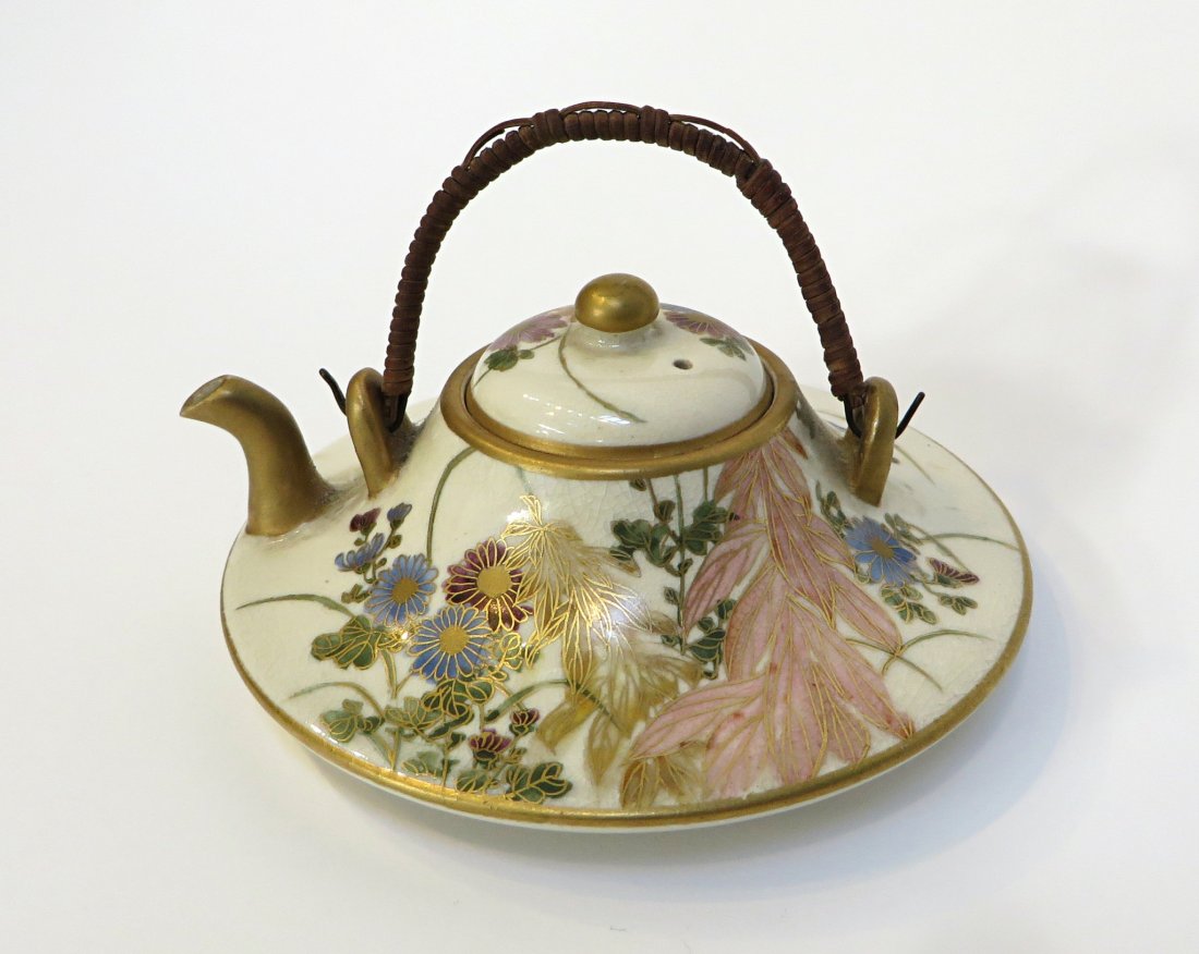 Small Teapot: A small lidded teapot, possibly Japanese. 4" across about 4" high with caned handle. Shipping: We are able to pack and ship this item to an address in the United States for $30.00 via USPS Priority Ma