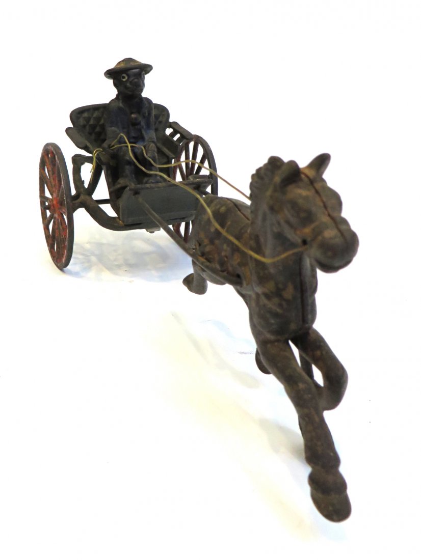 Cast Iron Surrey: A 12' long single man carriage in old paint, driven by a detachable black man. Reins are replaced. Shipping: We are able to pack and ship this item to an address in the United States for $40.00 via US