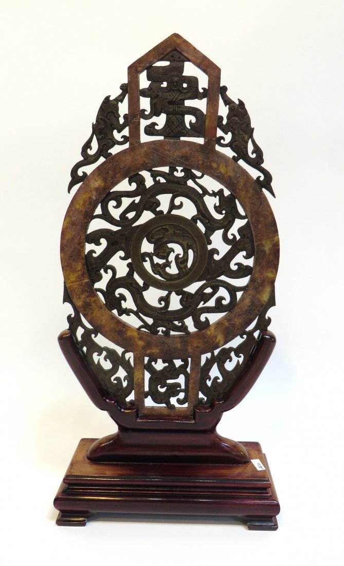 Chinese Soapstone Screen: A 16 1/2" standing soapstone sculpture of two colors, with elaborate dragon theme piercing and carving and a custom made polished wood stand. Note repair to crack extending across the piece diagonally