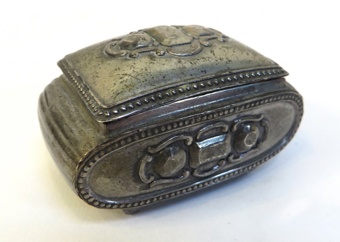 Pill Box: A silver toned casket or pill box with a hinged lid. 2 1/2" wide Shipping: We are able to pack and ship this item to an address in the United States for $25.00 via USPS Priority Mail. Tracking informa