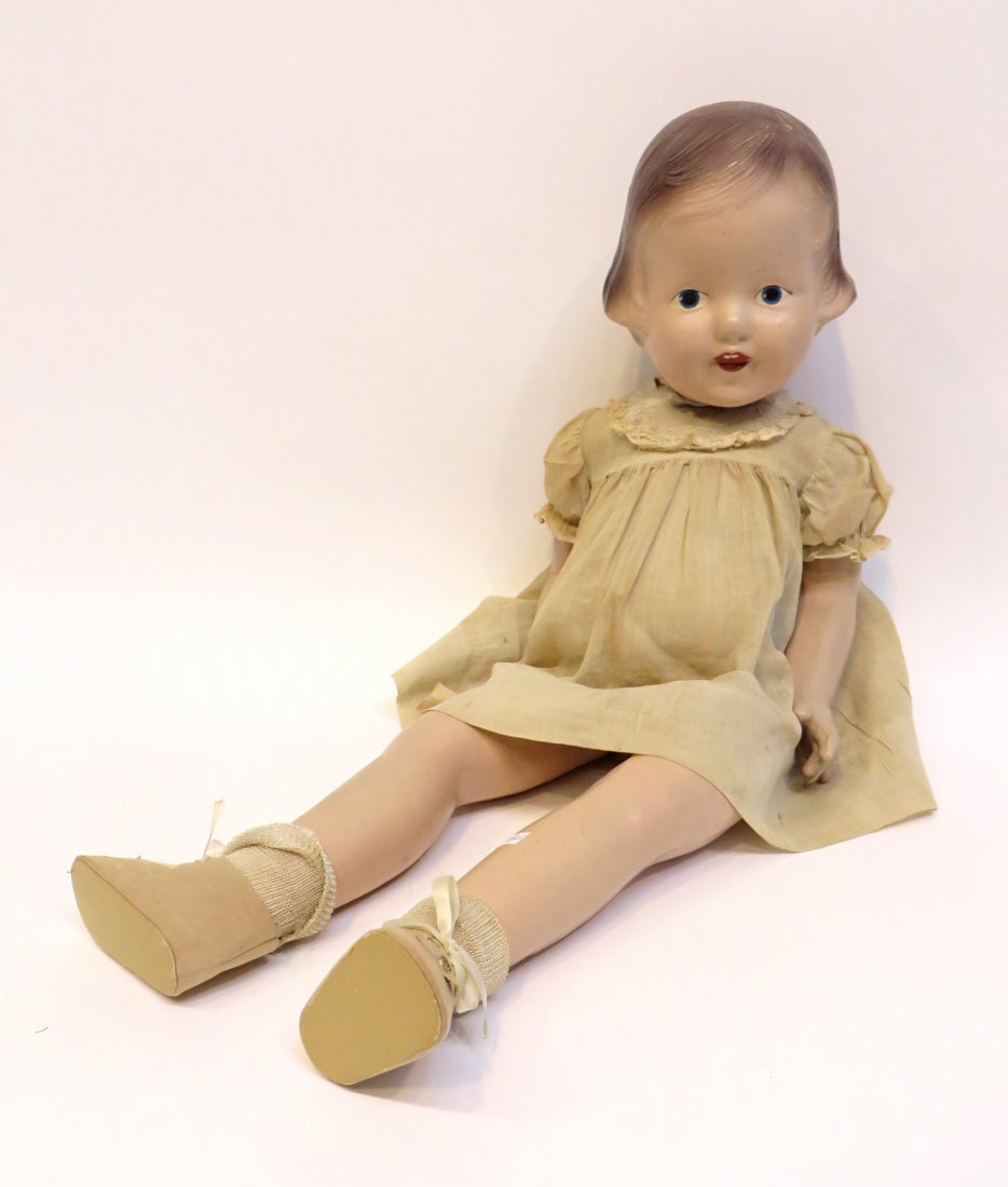 Patsy Ann Doll: In composition, and 22" in length, with a linen and lace frock dress and leather like shoes and socks. One finger broken off, some cracks in the head and loose joints in the head. Dress is faded altho