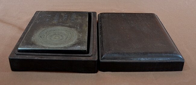 Duan Inkstone With Zitan Wood Box: A boxed Zitan wood Duan ink-stone, with Chinese poem inscribed on the lid. Box measures 7" X 5". Shipping: We are able to pack and ship this item to an address in the United States for $30.00 via USPS